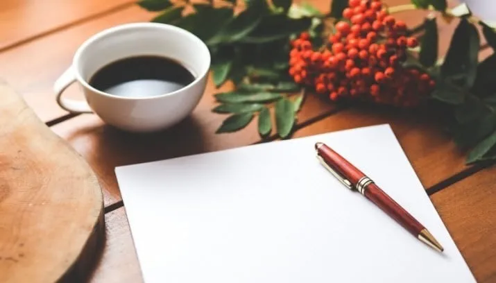 blank sheet of paper with ballpoint and coffee cup