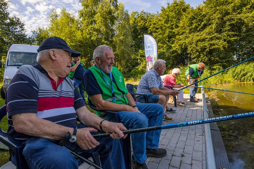 deelnemer en vrijwilliger lachen met overzicht visuitje