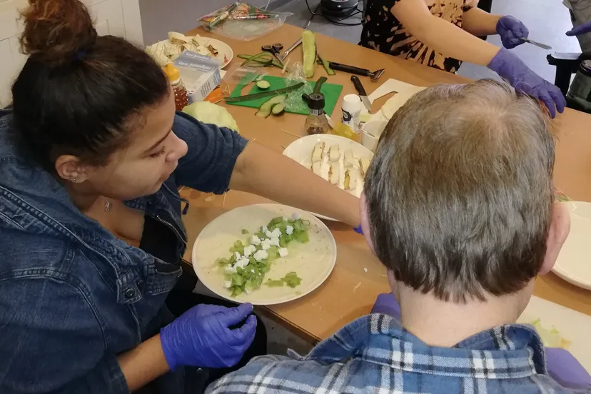 leerling van het rhedens dieren maakt samen met een bewoner hapjes