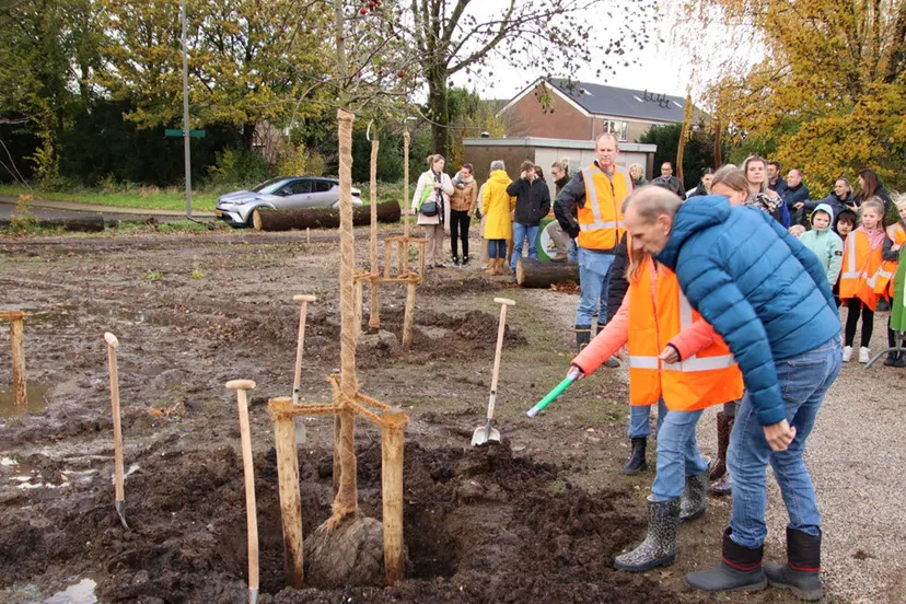 wethouder klomberg en kind plaatsen tijdcapsule onder boom