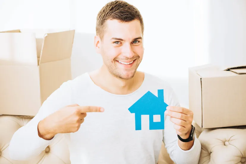 smiling-man-pointing-paper-house