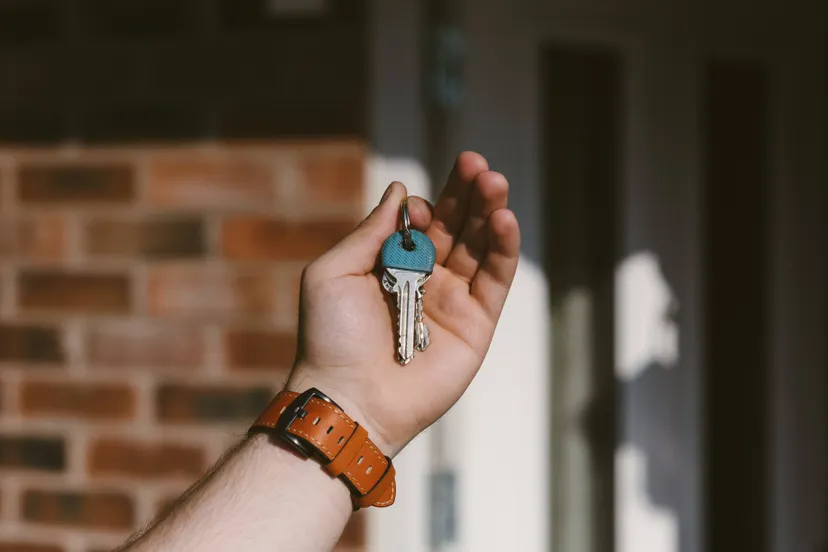 closeup-person-hand-holding-keys-with-blurred-background