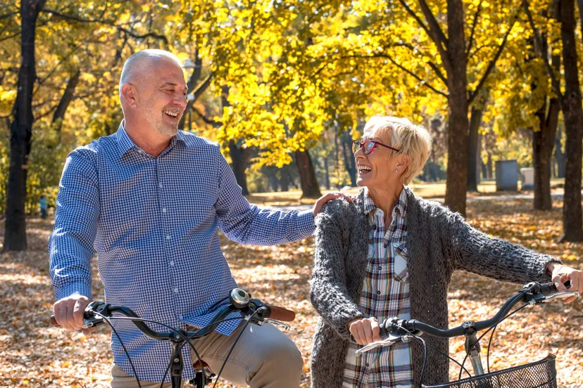 happy-elderly-couple-riding-bicycle-park-autumn