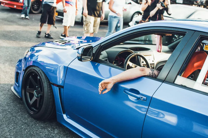 man-sits-blue-bmw-street
