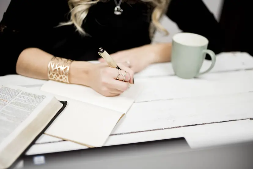 selective-closeup-shot-person-taking-notes-off-book