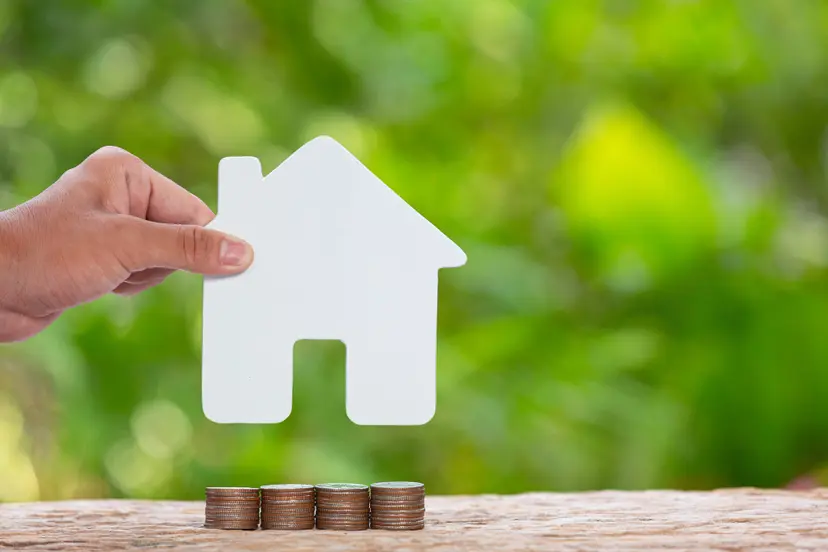 world-habitat-day-close-up-picture-pile-coins-andhand-holding-model-house
