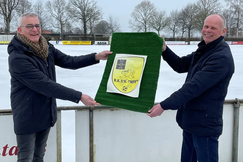 wethouder rene van ginderen links geeft nsv voorzitter jan gommers alvast een symbolisch stukje kunstgras 1