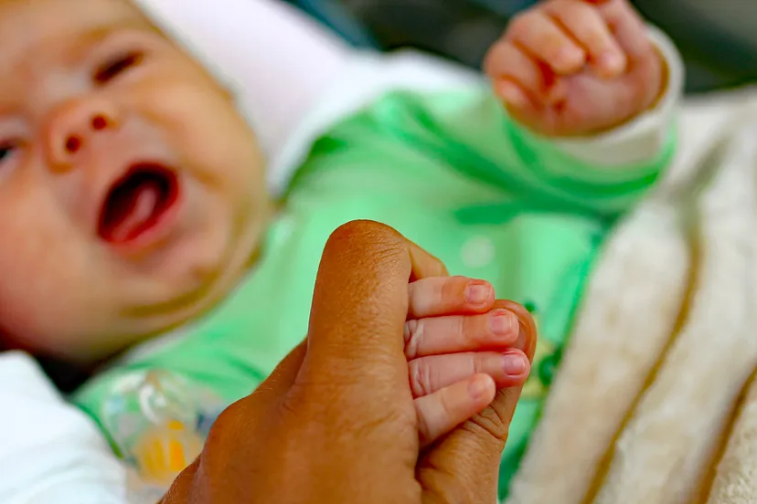 close up baby hand bed