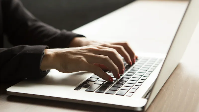 close up female hands typing laptop table