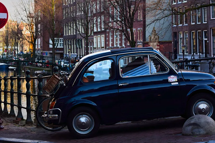 fiat 500 op voetpad brug over amsterdamse gracht
