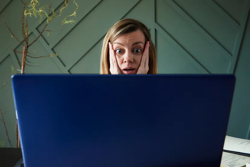 geschokte vrouw achter laptop