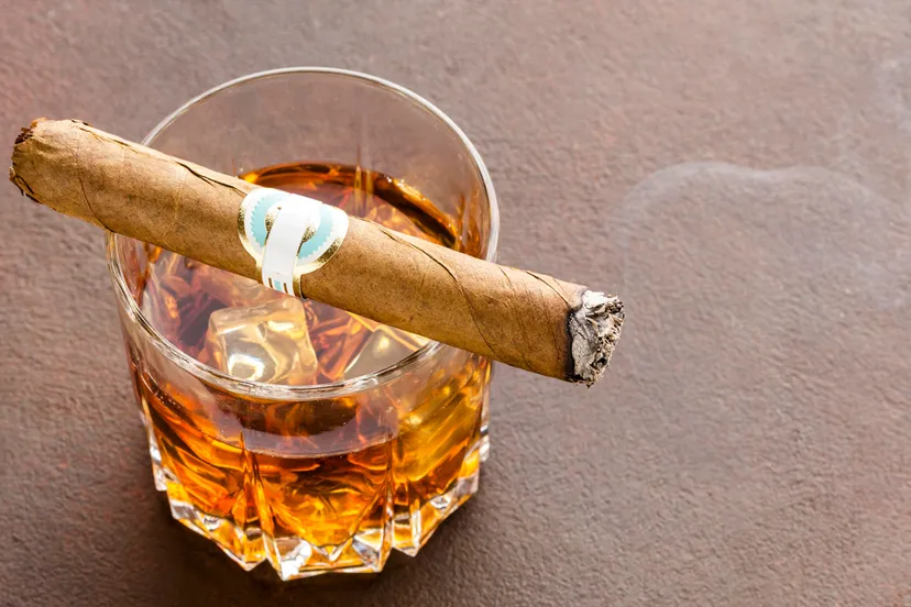 high angle whiskyglas met ijs en sigaar