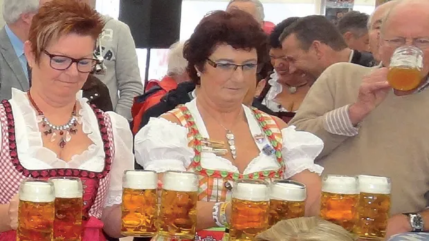 jidkji7y6nusenvdhopekyeok bierpullen en dames in dirndl