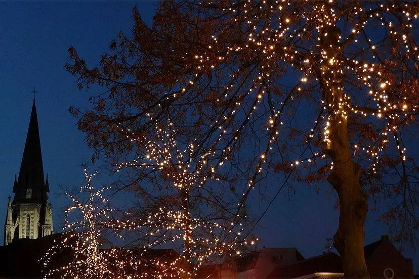 kerktoren en boom met kerstlichtjes