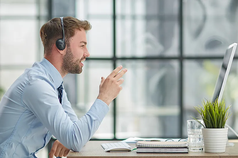 man met koptelefoon en laptop werken op kantoor