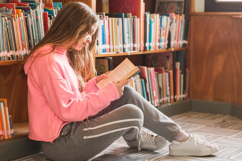 meisje leest boek boekenkast