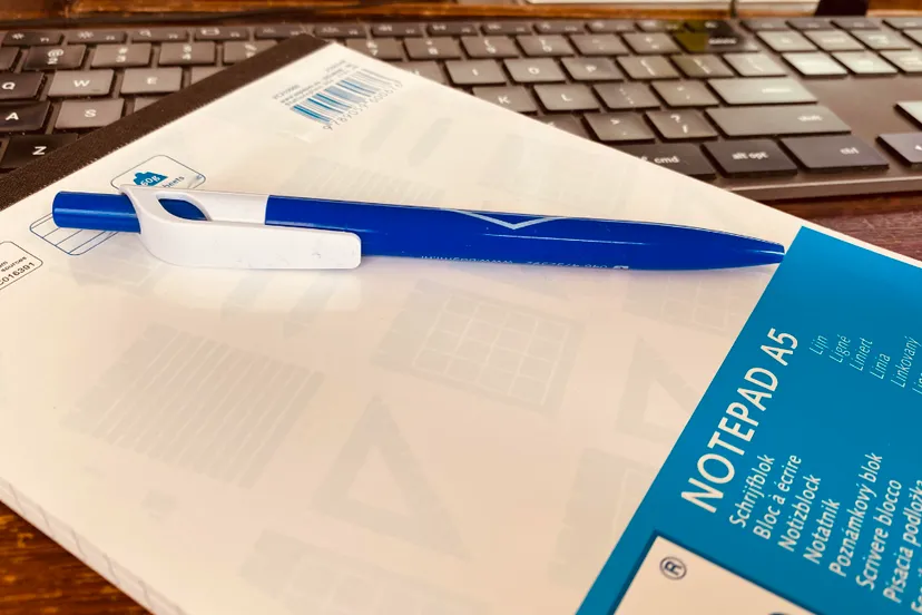 notitieblok met pen op toetsenbord