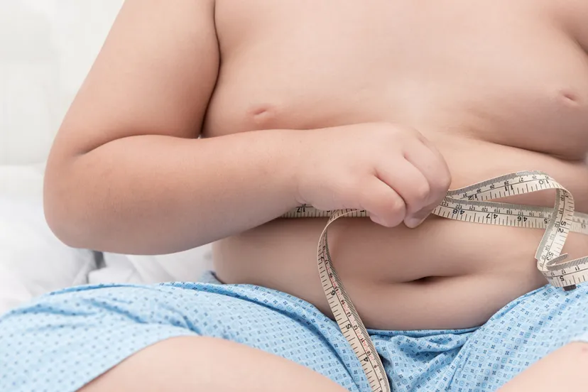 obesitas dikke jongen zijn buik meten met meting tape