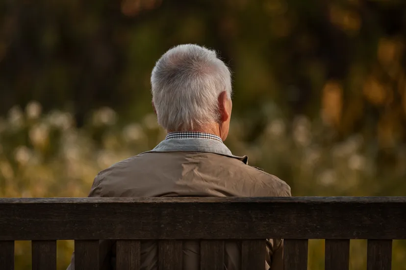 oudere man alleen op bankje