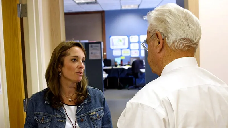 oudere werknemer praat met jondere werknemer