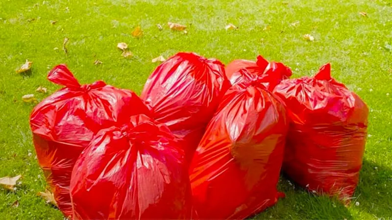 rode afvalzakken langs de weg