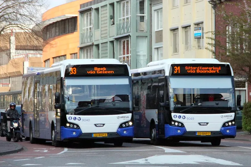 twee bussen van arriva naast elkaar voor het verkeerslicht