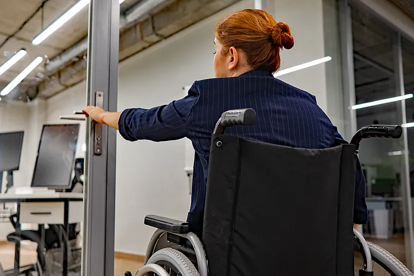 vrouw in rolstoel wil deur openmaken