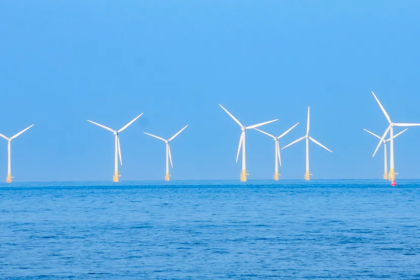 windturbines op zee gezien vanaf het strand