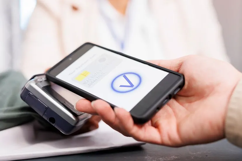 close up customer holding phone using nfc technology pay clothing making digital payment via pos terminal client paying retail store counter desk buying clothes fashion boutique