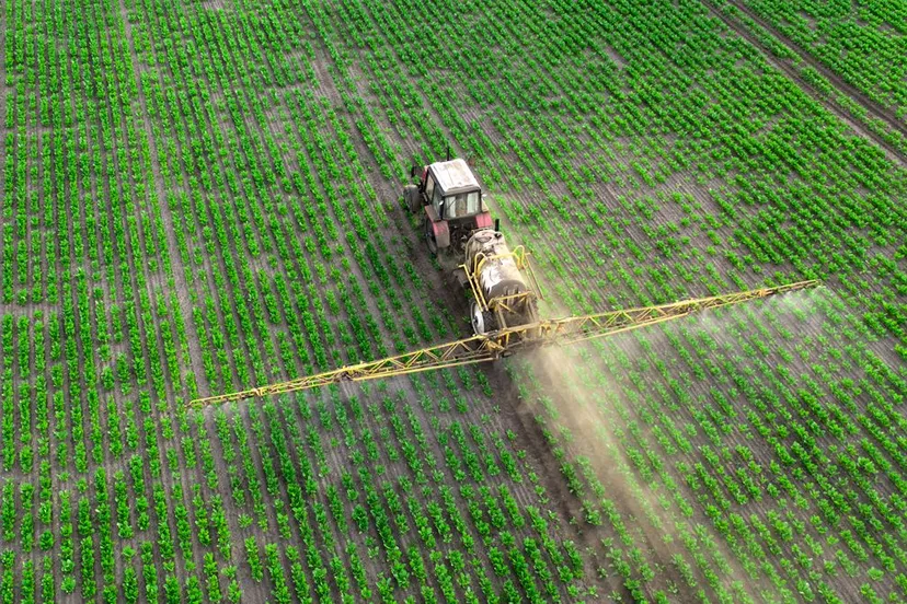 lanbouwer besproeit gewas met bestrijdingsmiddelen