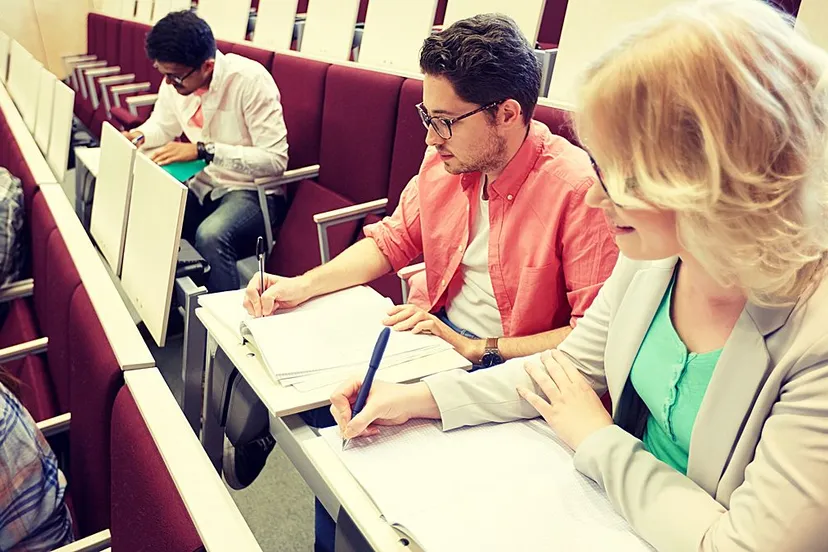 studenten maken aantekeningen in collegezaal