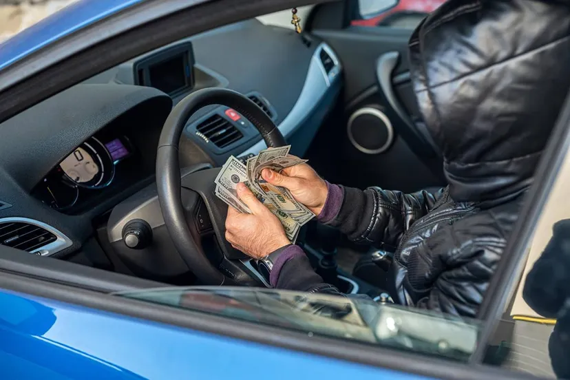 crimineel telt geld in auto