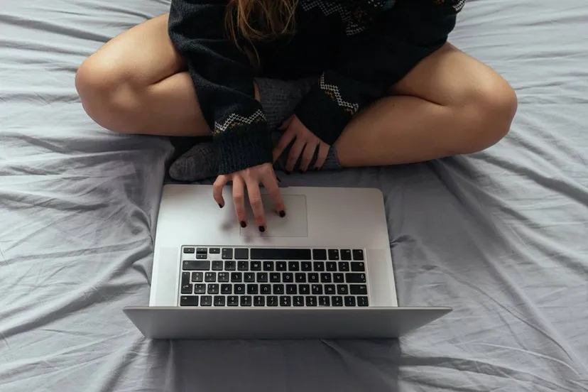 vrouw met laptop op bed