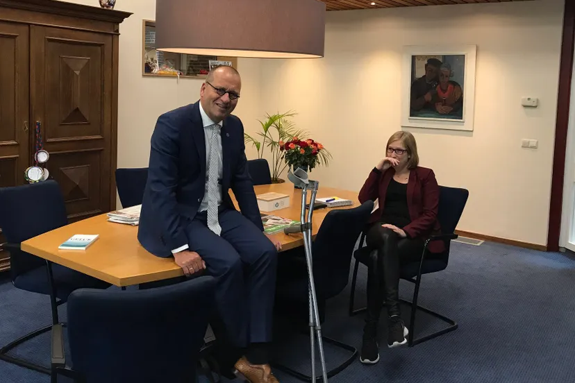 burgemeester blessure dijbeen zittend op tafel krukken e1510590368287