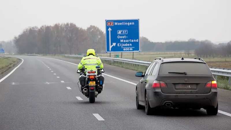 motoragent rijdt naast auto op snelweg1