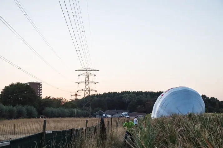 luchtballon landt langs hoogspanningsmasten