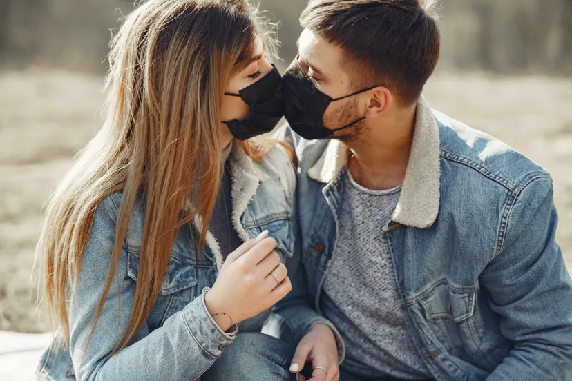 loving young couple kissing while wearing black medical 4005101