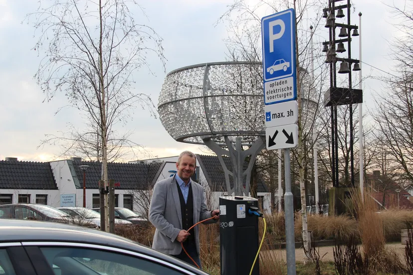 wethouder vleerbos naast laadpaal voor gemeentehuis