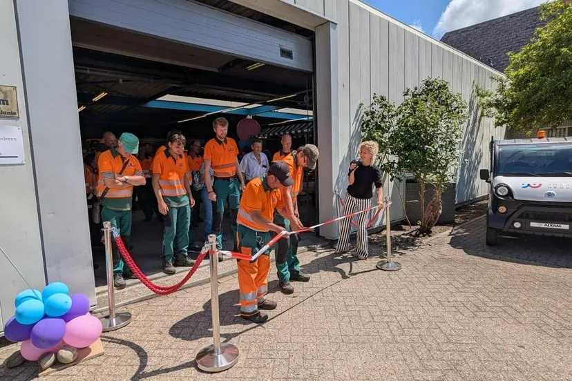 Fotobijschrift Groenmedewerkers knippen het lintje door van hun nieuwe locatie in Uitgeest