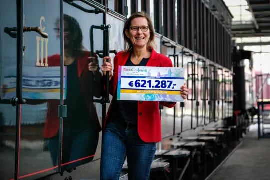 directeur nicole kuppens met de cheque van de bankgiro loterij