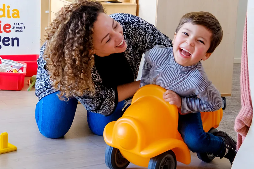 liggend kind en ouder spelen op de grond