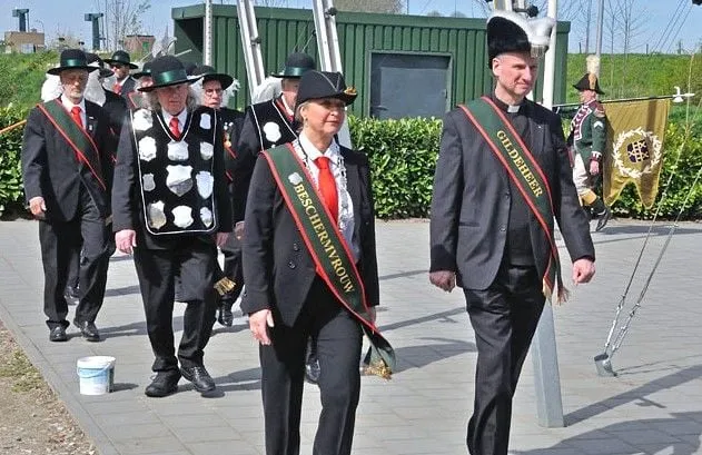 beschermvrouw en gildeheer samen met leden van het gilde in optocht