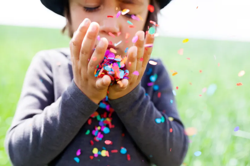 jongetje blaast confetti