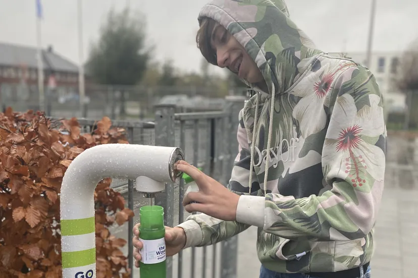 leerling van met praktijkonderwijs neemt watertappunt in gebruik