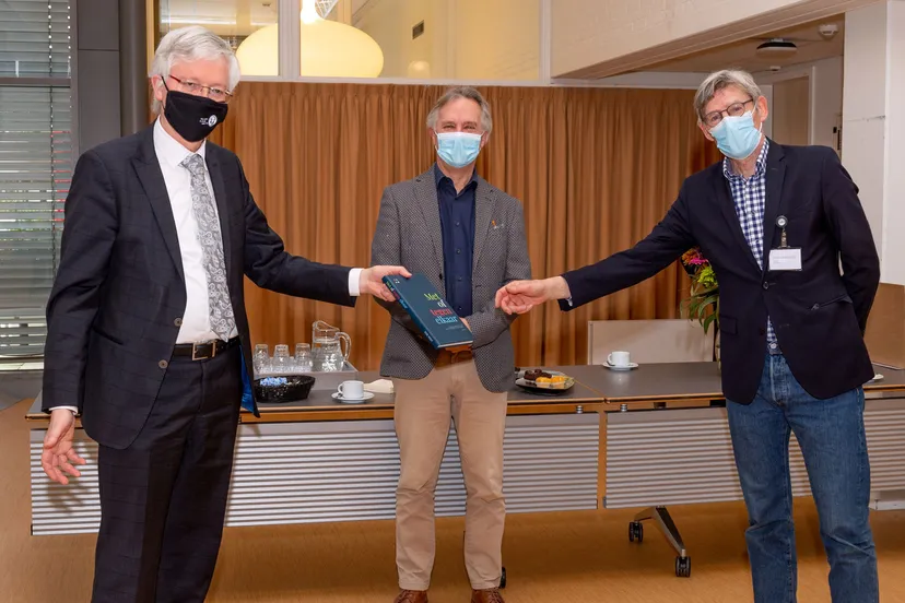 overhandiging boek met of tegen elkaar