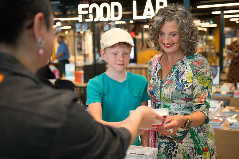 bezoeker bibliotheek lochal met medewerker