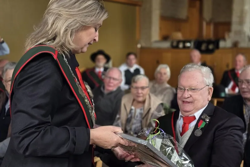 mari van loon ontvangt uit handen van burgmeester ausems een oorkonde en een stenen leest op standaard voor zijn bijzondere inzet voor het