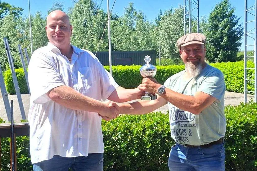 Koning Nick de Vaan (links) rijkt de Louw de Louw beker uit aan Hans Laghuwitz