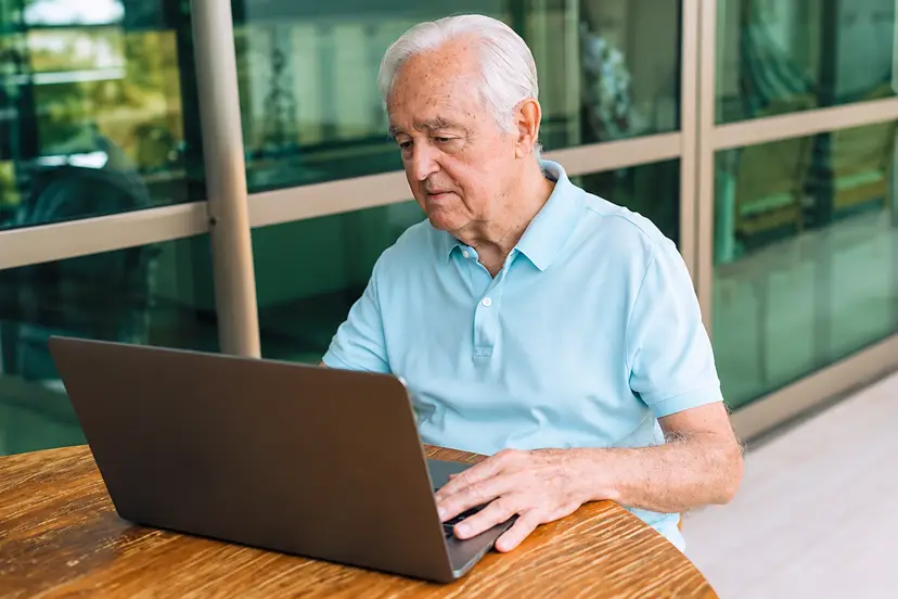 Senior man werkt op laptop