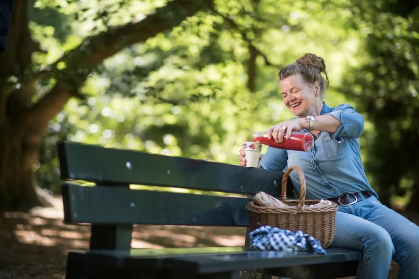 coolmenzisvrouw houdt gezonde picknick in de natuur